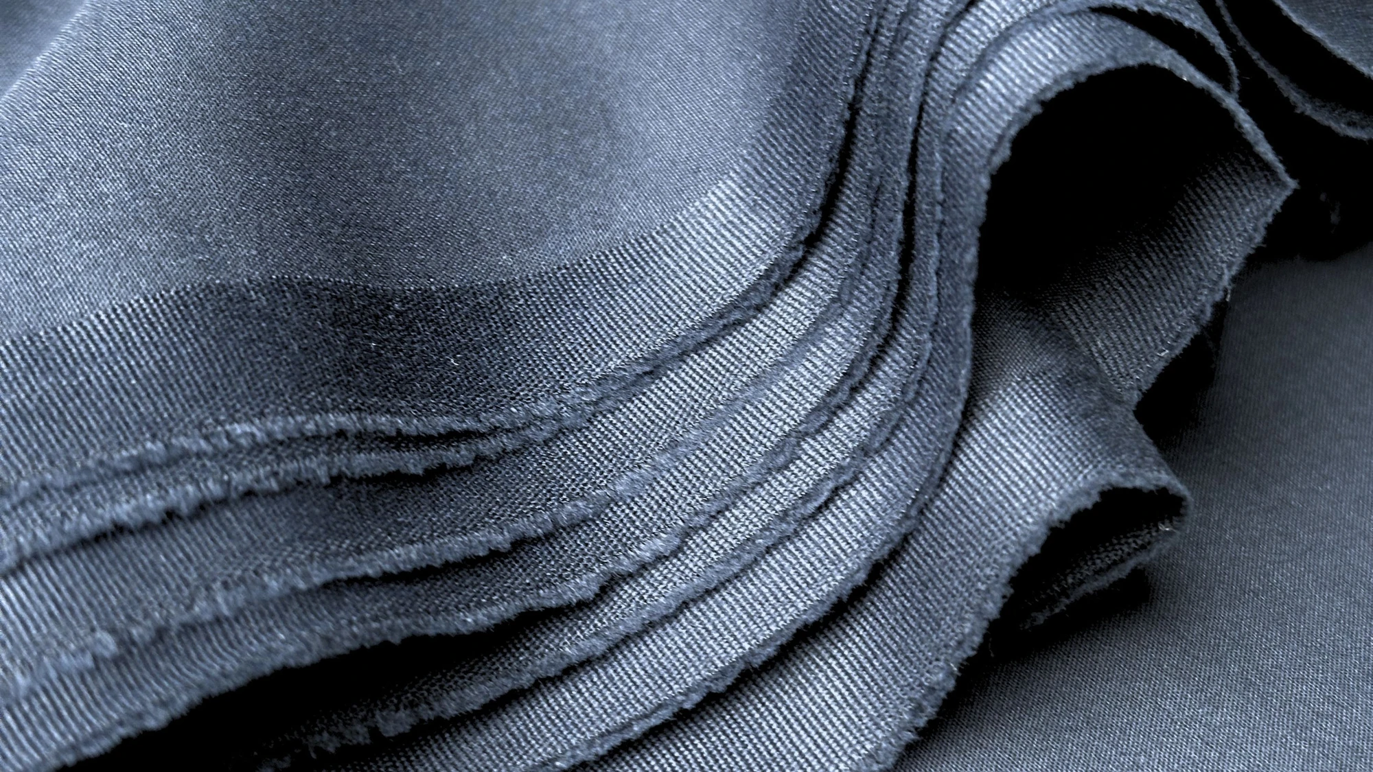 Plain polyester knit swatch beside a PU coated fabric swatch with its coated side up